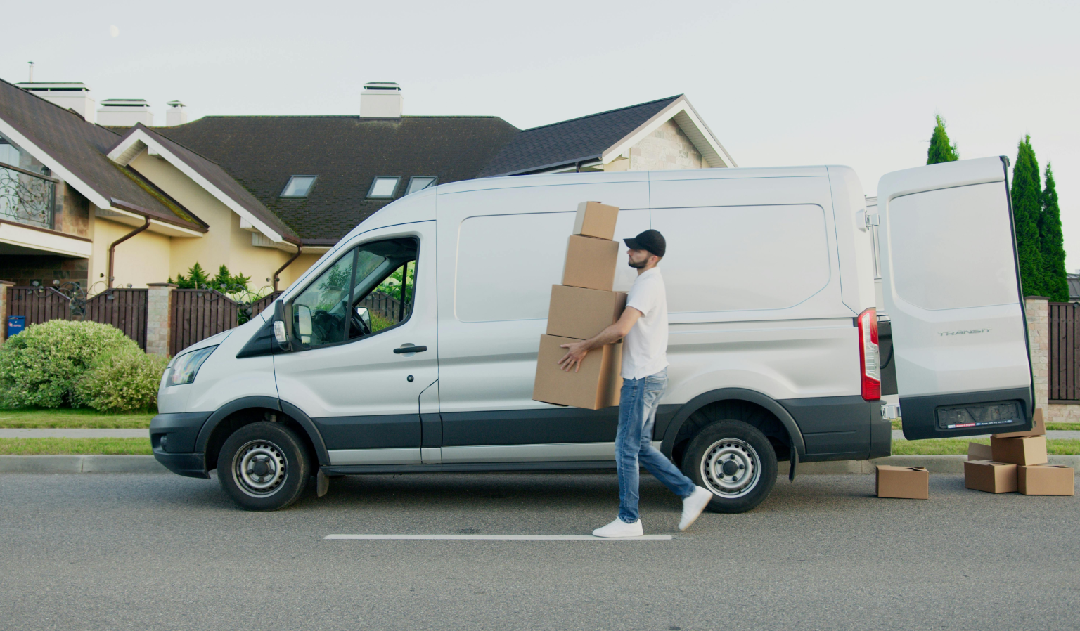 Lieferant mit Paketen vor einem Lieferwagen